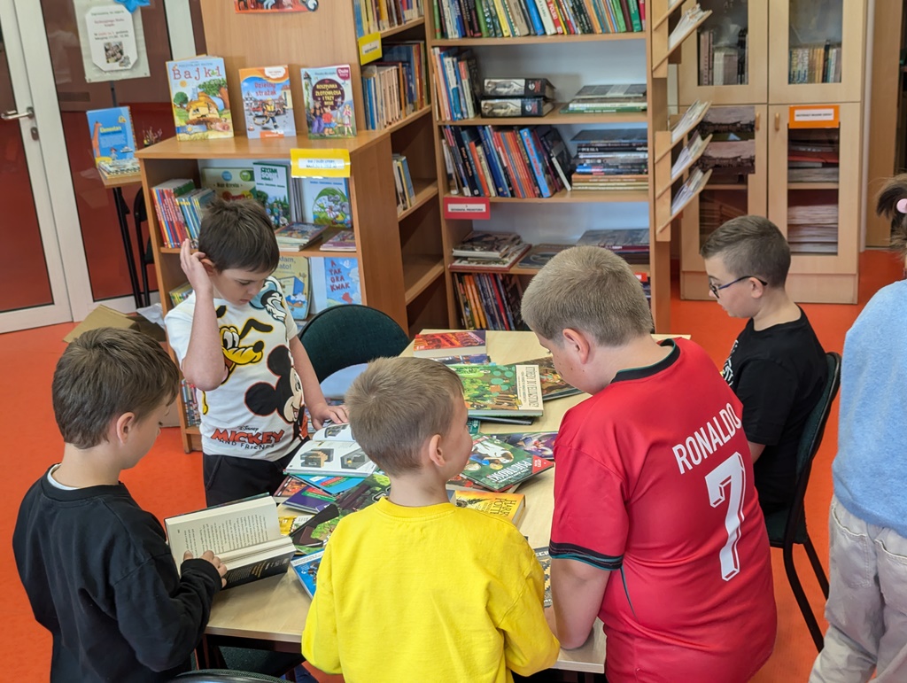 Uczniowie oglądają nowe książki w bibliotece