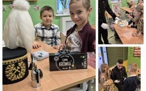 Uczniowie klasy 2d częstują się krówkami, na stole leży czapka zwana czako z godłem górniczym i pióropuszem z kogucich piór. 
