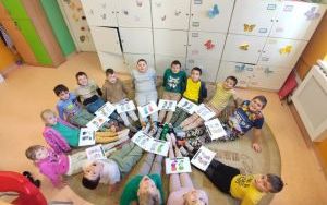 Uczniowie klasy 2c w dwóch różnych skarpetkach z pracami plastycznymi na nogach