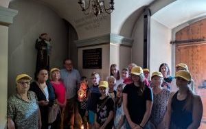 Uczestnicy wycieczki pod pamiatkową tablicą w kościele w Dębieńsku